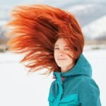 Winter haircut inspiration featuring long red hair and soft layered waves
