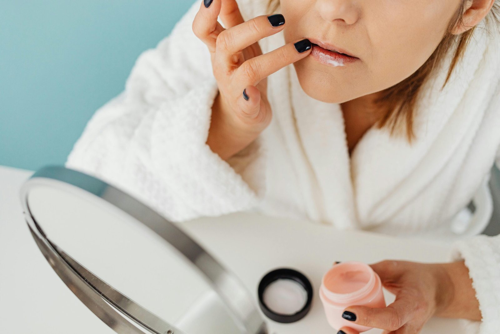 Woman applying lip balm during a cosy winter morning skincare routine
